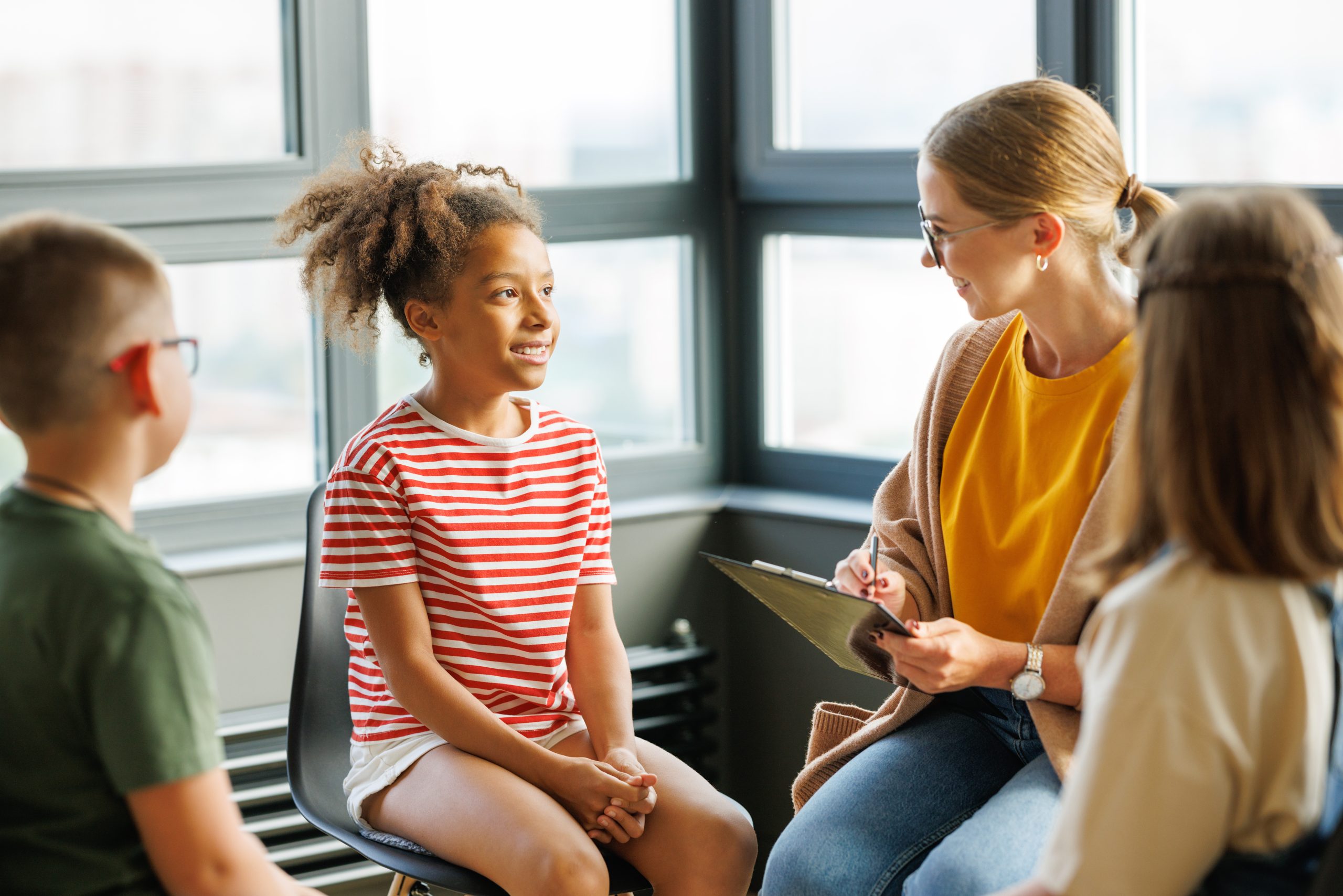 School psychologist with a group of children conducts a mental health lesson, group therapy, a psychotherapy session